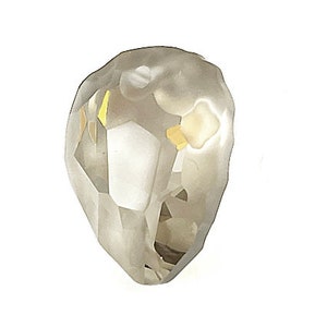 Pu&ograve; includere: Un cristallo sfaccettato a forma di goccia, di colore grigio chiaro. Il cristallo presenta molteplici sfaccettature che riflettono la luce, creando un effetto scintillante. Piccoli accenti color oro sono visibili all'interno del cristallo.