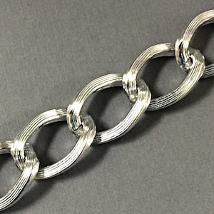 May include: A silver chain with a textured, oval-shaped link design.