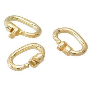 May include: Three gold-colored oval carabiner clasps. Two are closed, and one is open, showing the locking mechanism. The clasps are made of a shiny, metallic material.