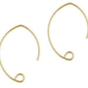 May include: A pair of gold-toned hoop earrings with a simple, oval shape. The earrings have a small loop at the bottom for attaching charms or pendants.