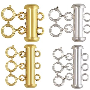 May include: Four multi-strand jewelry clasps in gold and silver. Each clasp has a cylindrical center with multiple loops for attaching strands. The clasps have spring ring closures. The gold clasps are on the left, and the silver clasps are on the right.