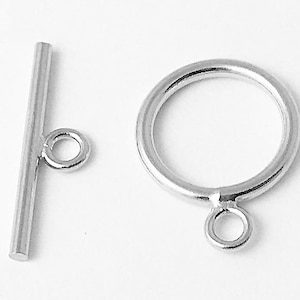 May include: Silver-toned metal toggle clasp with a round ring on one end and a straight bar with a round ring on the other end.