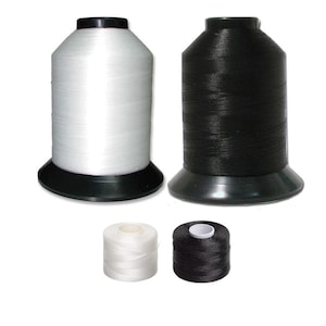 May include: Two spools of white and black thread, each with a smaller spool of the same color thread.