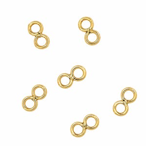 May include: A collection of six gold-colored metal connectors, each featuring two circular rings joined together in a figure-eight shape. These small jewelry components have a smooth, polished finish and are arranged in a scattered pattern.