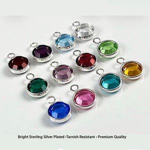 May include: A collection of bright, colorful gemstone charms with silver-colored settings. The charms are in various colors, including red, purple, green, blue, and yellow. The text at the bottom reads: Bright Sterling Silver Plated • Tarnish Resistant • Premium Quality.