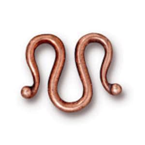 May include: A copper-toned metal toggle clasp with a unique S-shaped design. This clasp is perfect for necklaces, bracelets, and other jewelry projects.