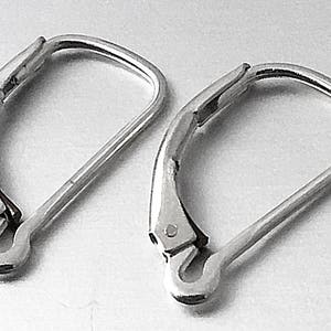 May include: A pair of silver-toned earring closures. The closures are made of metal and have a smooth, polished finish.