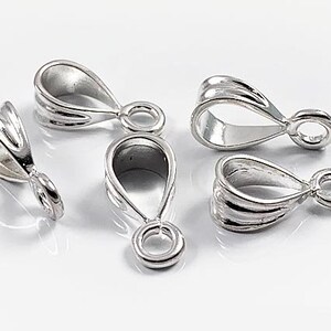 May include: Five silver-toned metal pendant bails with a loop at the top and a teardrop shape. The bails have a smooth, polished finish.