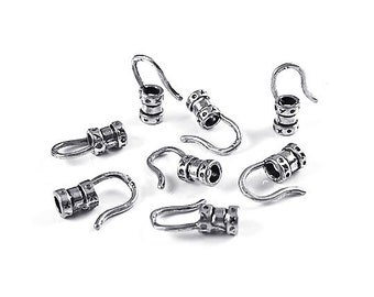 May include: Silver-toned metal cord ends with a hook and decorative details. The cord ends are designed to be used for jewelry making or other crafting projects.