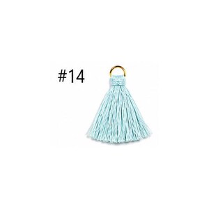 Peut inclure: Un pompon bleu clair dot&eacute; d'un anneau en m&eacute;tal dor&eacute; sur le dessus pour la fixation. Le pompon est compos&eacute; de nombreux fils fins suspendus et porte l'inscription #14 positionn&eacute;e sur la gauche de l'objet.