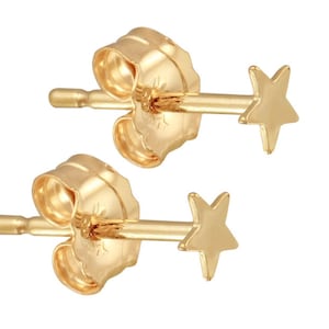 May include: A pair of gold star stud earrings. The earrings are small and delicate, with a simple star design.