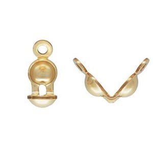 May include: Gold metal bead caps for jewelry making. The caps are designed to be used with round beads and have a small loop at the top for attaching to a chain or cord.