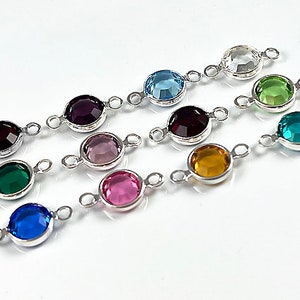 Puede incluir: Surtido de 10 dijes conectores plateados con piedras de cristal de diferentes colores. Cada dije tiene dos lazos para sujetar a las joyas.