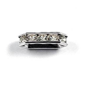 May include: A silver-toned metal ring with five clear rhinestones set in a row.