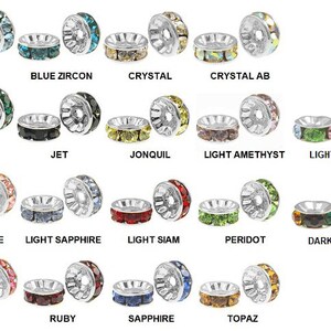 May include: A collection of gemstone beads in various colors, including aquamarine, emerald, ruby, and sapphire. Each bead has a silver-colored metal rim and is labeled with its gemstone name. The beads are designed for jewelry making.