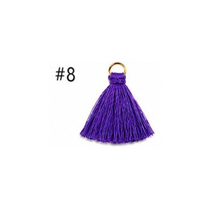 Peut inclure: Un pompon violet vif compos&eacute; d'une collection dense de fils fins et soyeux rassembl&eacute;s au sommet. Un petit anneau m&eacute;tallique dor&eacute; est fix&eacute; au n&oelig;ud tress&eacute; &agrave; la base. Le texte #8 est visible sur la gauche du pompon.