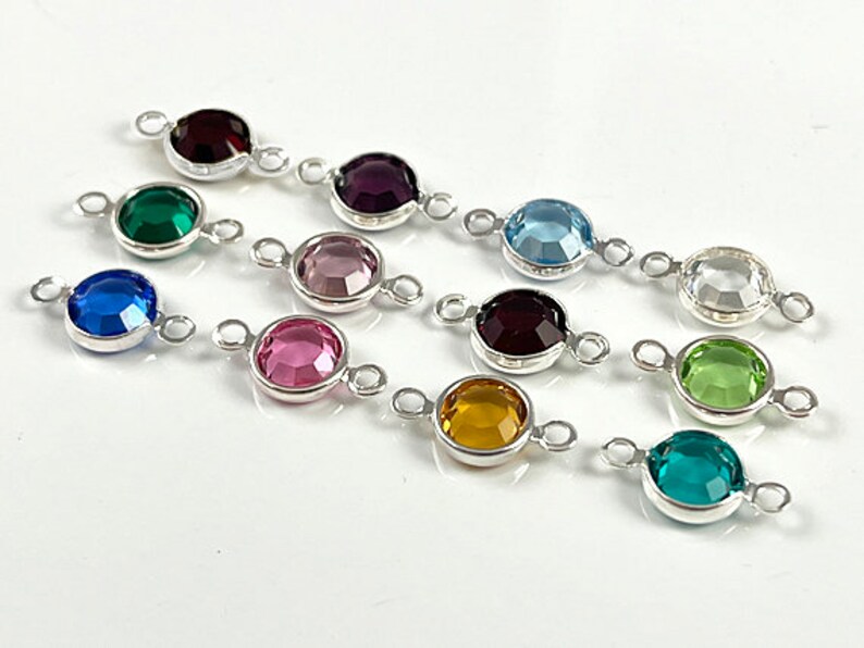 Puede incluir: Surtido de 10 abalorios redondos de cristal conector en varios colores, incluyendo verde, azul, morado, rosa y transparente. Cada abalorio tiene dos lazos plateados para sujetar a las joyas.