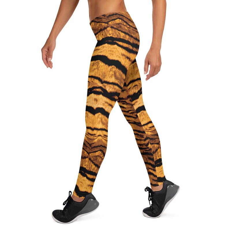 May include: A pair of black leggings with a tiger print pattern. The leggings are made of a stretchy, comfortable fabric and are perfect for working out or running errands.