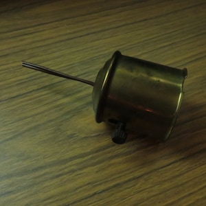 May include: A brass lamp socket with a black knob and two wires extending from the side.