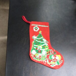 May include: Red Christmas stocking with a green Christmas tree and Peanuts characters. The stocking has the text "Merry Christmas" on the front.