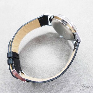 May include: A silver wristwatch with a black leather band. The watch face is not visible.
