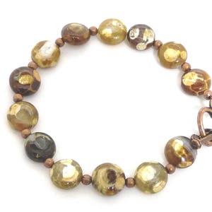 May include: A brown and gold agate bead bracelet with a copper heart-shaped clasp.