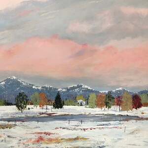 May include: A snowy landscape with a pink sky and a mountain range in the background. There is a small pond in the foreground with trees lining the edge.