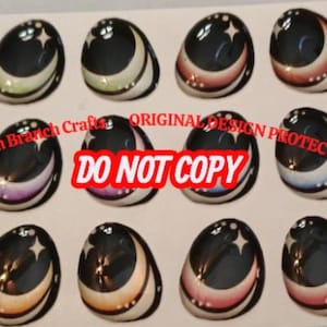 May include: A collection of oval doll eyes featuring a black iris, a crescent moon, and a star design. The eyes display a range of colours, such as brown, pink, and green. The text "DO NOT COPY" is visible.