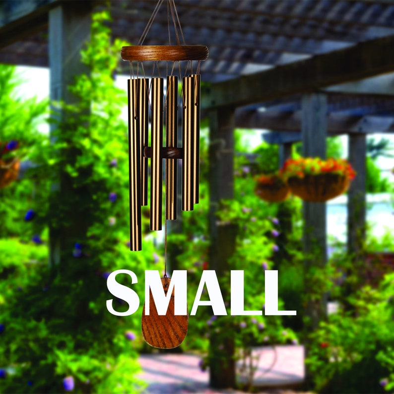 May include: A small, wooden-framed wind chime with multiple metal tubes hanging from it. The wind chime is hanging from a pergola in a garden setting. The word "SMALL" is printed in white letters on the image.