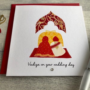 Anand Karaj Sikh wedding card. Illustration shows the Sikh couple sitting before the Guru Granth Sahib (Sikh Holy Book) Front is printed with, Vadiya (congratulations) on your wedding day.
