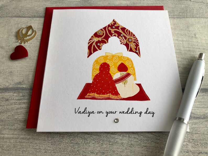 Anand Karaj Sikh wedding card. Illustration shows the Sikh couple sitting before the Guru Granth Sahib (Sikh Holy Book) Front is printed with, Vadiya (congratulations) on your wedding day.