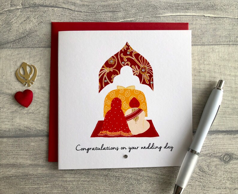 Anand Karaj Sikh wedding card. Illustration shows the Sikh couple sitting before the Guru Granth Sahib (Sikh Holy Book) The card is finished with diamanté. and reads Congratulations on your wedding day.