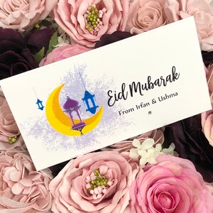 Personalised Eid Mubarak envelopes with a moon and lantern design printed onto white quality 300gsm card. Front reads Eid Mubarak with name/s of person gifting. Finished with diamante for extra sparkle.