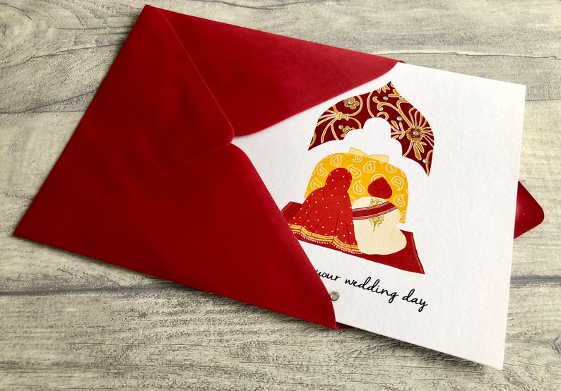 Anand Karaj Sikh wedding card. Illustration shows the Sikh couple sitting before the Guru Granth Sahib (Sikh Holy Book) Shown with red envelope. Front is printed with, Congratulations on your wedding day.