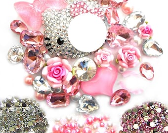 May include: Assortment of pink and silver rhinestones, pearls, and glitter.  The rhinestones are in various shapes, including hearts, ovals, and teardrops.  There is also a large, silver Hello Kitty charm.