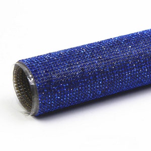 Può includere: Un rotolo di passamaneria di strass blu. La passamaneria è realizzata con piccoli strass scintillanti incollati su un supporto flessibile.