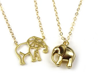 May include: Two gold elephant necklaces. One necklace features a detailed, cutout elephant pendant, while the other has a solid, three-dimensional elephant pendant.