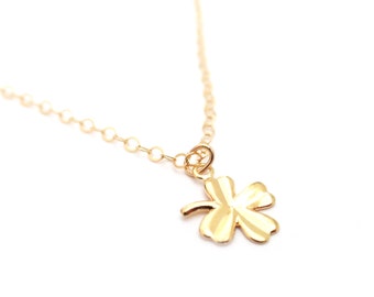 May include: A gold chain necklace with a four-leaf clover pendant.