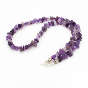 May include: A purple amethyst chip necklace with a silver clasp. The necklace is made of small, irregular pieces of amethyst.
