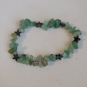 May include: A green stone bracelet with silver star charms and a silver bead.