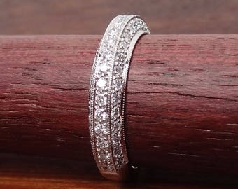 May include: A silver band ring with a row of small diamonds set in a pave setting.
