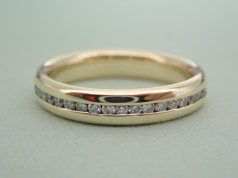 May include: A gold band with a single row of small diamonds set into the metal.