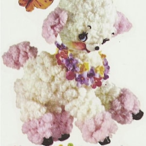 May include: A white crocheted lamb with pink ears and feet, wearing a colorful flower garland. The lamb is standing on a white background with flowers.