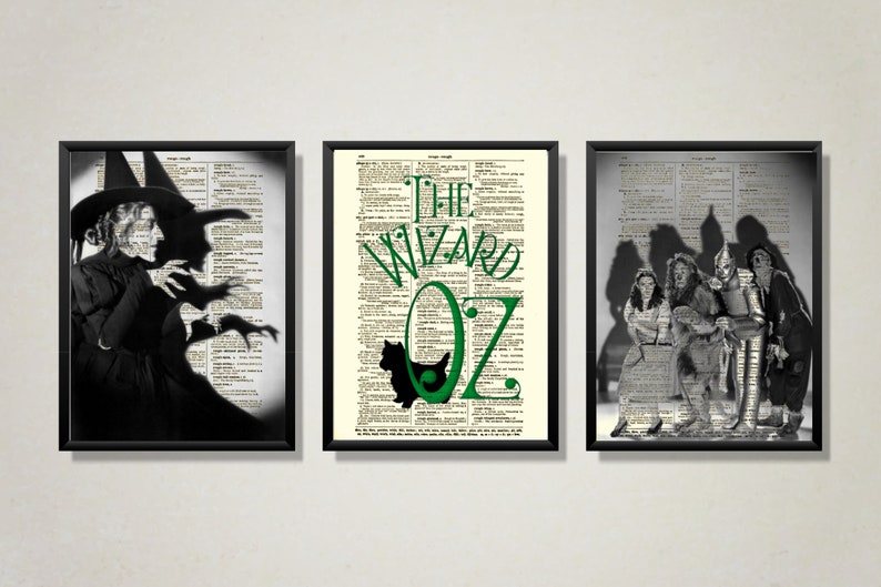 May include: Three black framed prints with a vintage dictionary page background. The left print features a black and white image of the Wicked Witch of the West from The Wizard of Oz. The middle print features the text "The Wizard of Oz" in green text. The right print features a black and white image of Dorothy, the Scarecrow, the Tin Man, and the Cowardly Lion from The Wizard of Oz.