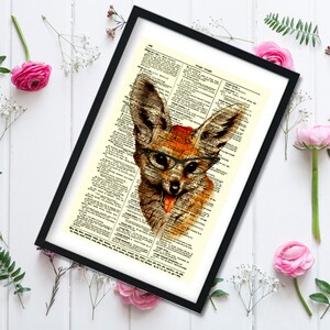May include: Framed art print featuring a whimsical illustration of a fox wearing glasses, set against a vintage dictionary page background. The fox is depicted in shades of brown and orange, with a red accent on its head.
