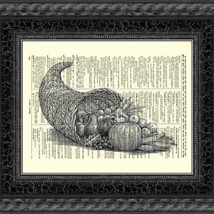 May include: Framed black and white print of a cornucopia filled with produce. The illustration is on a vintage dictionary page, set within a black textured frame, suitable for a kitchen or dining room.