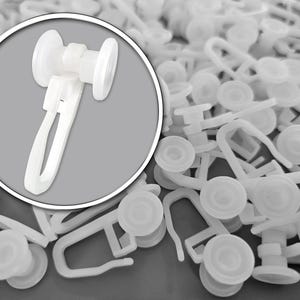 Op de afbeelding: Witte plastic gordijnrails met een clipontwerp. De afbeelding toont een close-up van een enkele rol en een stapel vergelijkbare rollen, ideaal voor raambekleding. De rollen hebben een cirkelvorm met een centrale clip.