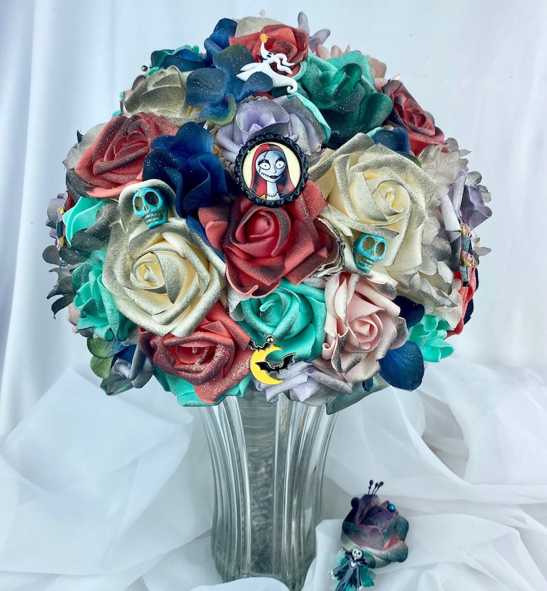 May include: A bouquet of artificial flowers in shades of red, white, green, and blue. The bouquet features a variety of flowers, including roses, orchids, and lilies. The bouquet is decorated with a variety of embellishments, including skulls, bats, and a character from the movie The Nightmare Before Christmas. The bouquet is arranged in a clear glass vase.