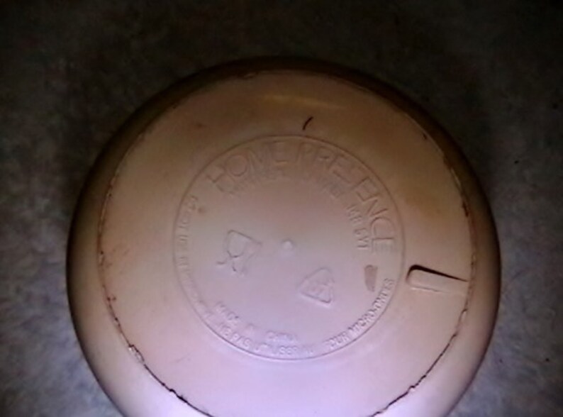 May include: A white round lid with the words "Home Preference" printed on it. The lid has a small crack on the side.
