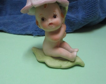 Adorable baby under a flower petal figurine vintage